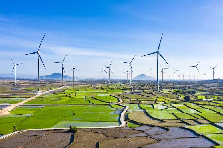 Aerial Drone View of Windmill Energy Farm - Landscape with Turbine Green Energy Production -  Wind turbines Generating Electricity On Green Rice Field; Shutterstock ID 1993487015; other: -; purchase_order: -; client: -; job: -